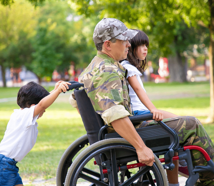 veteran being pushed in wheelchair by child